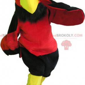 Mascotte de vautour rouge et jaune avec un short noir -