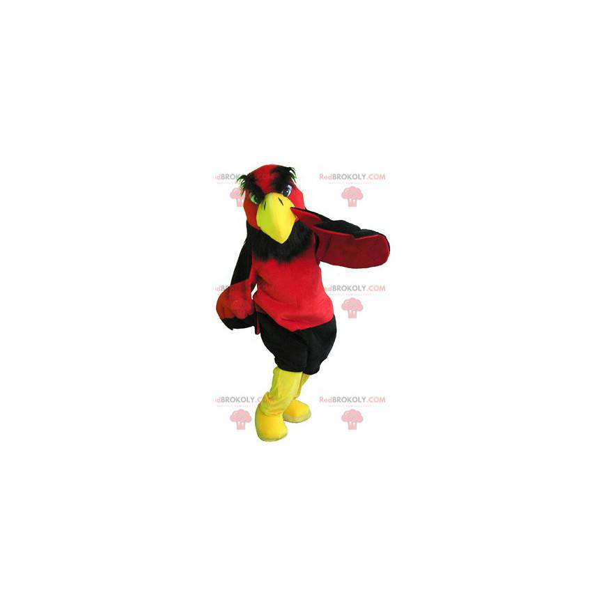 Mascotte de vautour rouge et jaune avec un short noir -
