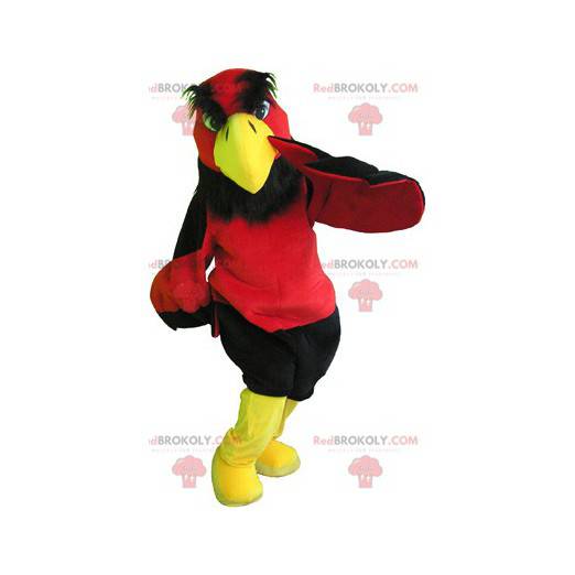 Mascotte avvoltoio rosso e giallo con pantaloncini neri -