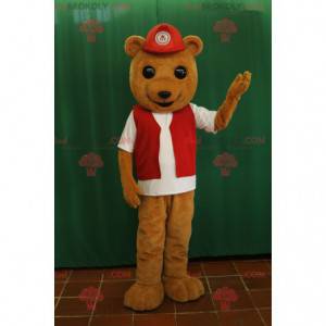 Mascotte dell'orso bruno con un giubbotto e un berretto rossi -
