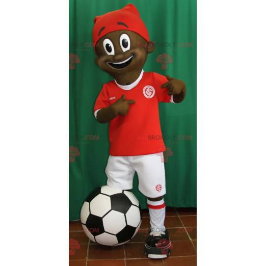 Mascota niño africano joven en traje de futbolista -