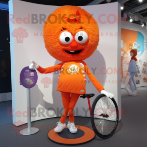 Orange Unicyclist mascot costume character dressed with a Shorts and Shawl pins