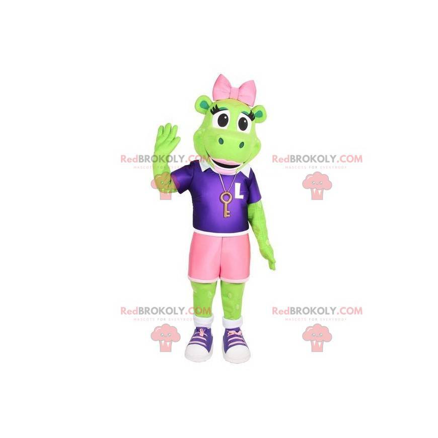 Grünes Froschmaskottchen mit Shorts und einer rosa Schleife -