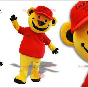 Žlutý medvěd maskot oblečený v červené barvě s víčkem -