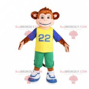 Macaco mascote marrom vestido com uma roupa colorida -