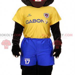 Mascote tigre preto em roupas esportivas amarelas e azuis -