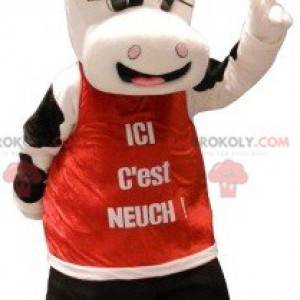 Mascotte de vache blanche et noire avec un dossard rouge -