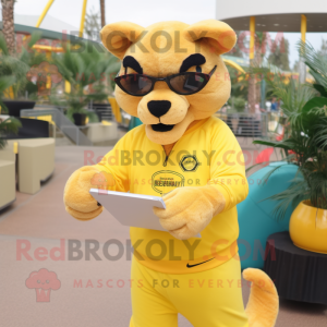 Yellow Puma mascot costume character dressed with a Rash Guard and Reading glasses