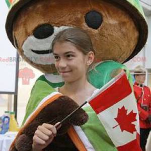 Brown bear mascot with a cape and a green helmet -