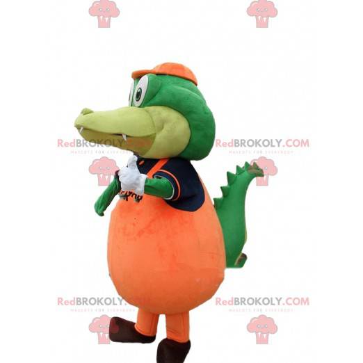 Zielony krokodyl maskotka ubrany w pomarańczowy kostium
