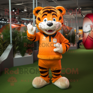 Orange Tiger mascot costume character dressed with a Rugby Shirt and Hat pins