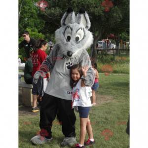 Mascote lobo cinza e branco em roupas esportivas -